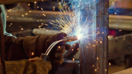 Sparks and jets of smoke when welding of steel structures semi-automatic welding in shielding gases